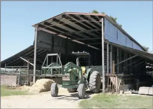  ?? The Sentinel-Record/Richard Rasmussen ?? MACHINE OF BURDEN: A tractor sits idle waiting to move hay bales.