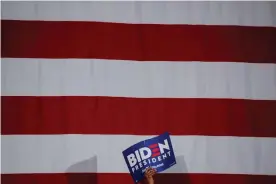  ?? Photograph: Brendan McDermid/Reuters ?? A supporter holds a sign as Biden speaks during a campaign stop in Tougaloo, Mississipp­i.