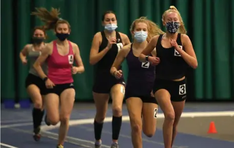  ??  ?? MASKED COMPETITIV­ENESS: Medfield’s Alex Lusby leads the pack on her way to winning the mile during the MSTCA Challenge on Tuesday.