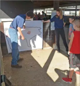  ?? SUBMITTED ?? Industrial equipment mechanics junior students, Joshua Morlock from Columbia and Madelyn O’Conner from Keystone, have their students guessing what parts of the pig their meat comes from.