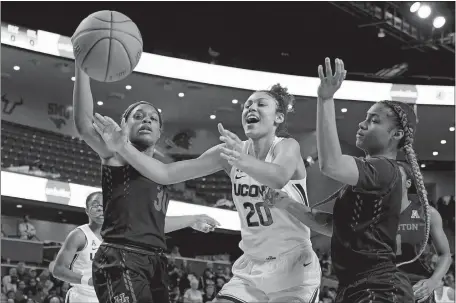  ?? DAVID J. PHILLIP/AP PHOTOS ?? Above, UConn’s Olivia Nelson-Ododa reaches for a loose ball with Houston’s Tatyana Hill, left, and Dorian Branch during the first half Saturday in Houston. Nelson-Ododa finished with 14 points and nine rebounds as the Huskies, who led by 27 after the first quarter, cruised to a 92-40 win. Below, UConn’s Anna Makurat looks to shoot Saturday as Houston’s Julia Blackshell-Fair defends during the first half.