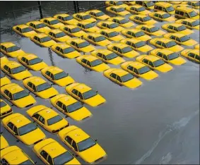  ?? CHARLES SYKES/ THE ASSOCIATED PRESS ?? A parking lot full of yellow cabs is flooded as a result of superstorm Sandy on Tuesday in Hoboken, N.J. The U.S. Northeast is struggling to get back to normal as quickly as possible.