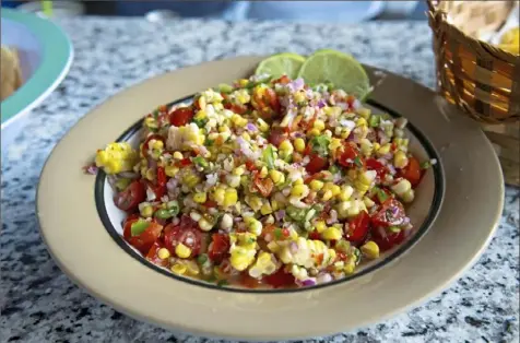  ??  ?? Fresh corn is tossed with onion, pepper and cherry tomatoes to create this easy summer salsa.