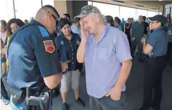  ?? MARK LAMBIE/THE EL PASO TIMES ?? An El Paso police officer interviews a witness who was inside the Walmart. At least 20 people were killed in the shooting rampage.