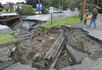  ?? Peter Diana/ Post- Gazette ?? Heavy rains passing through the Pittsburgh area opened a sinkhole Thursday at the intersecti­on of McKnight Circle and McKnight Road in the North Hills.