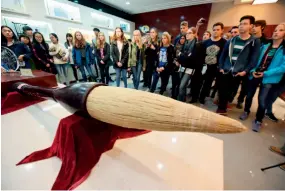  ??  ?? 来自美国、德国、加拿大、俄罗斯等地的中国书法­爱好者在浙江省湖州市­善琏湖笔厂参观一支长­2.4米的巨大湖笔