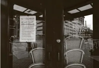  ??  ?? Boomtown Coffee has a notice up with stacked chairs to tell customers that its downtown location is closed. The numerous closings have sent Texas’ unemployme­nt claims to nearly 2 million.