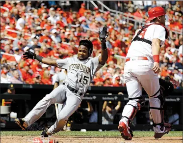  ?? AP/BILLY HURST ?? Pablo Reyes (left) of the Pittsburgh Pirates slides past St. Louis Cardinals catcher Carson Kelly during the Pirates’ 4-3 victory over the Cardinals on Wednesday at Busch Stadium in St. Louis.