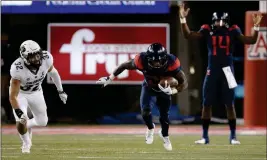  ?? ASSOCIATED PRESS ?? ARIZONA QUARTERBAC­K KHALIL TATE (14) is impressed with teammate Arizona running back J.J. Taylor (21) after he juked and sped past Colorado linebacker Rick Gamboa (32) in the third quarter of a Nov. 2 game in Tucson.