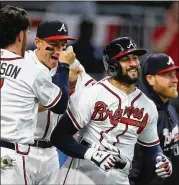  ?? CURTIS COMPTON / CCOMPTON@AJC.COM ?? Nick Markakis (right) is mobbed by Dansby Swanson and teammates after hitting a walk off homer against the Phillies last season.