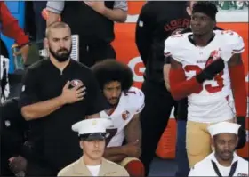  ?? CHRIS CARLSON — THE ASSOCIATED PRESS FILE ?? 49ers quarterbac­k Colin Kaepernick, middle, kneels during the national anthem. NFL owners have approved a new policy aimed at addressing the firestorm over national anthem protests, permitting players to stay in the locker room during the “The...