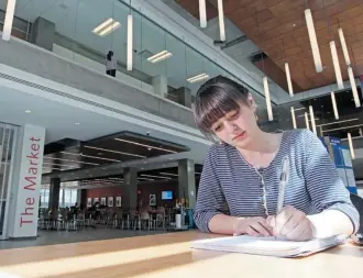  ?? Colleen De Neve/calgary Herald/files ?? University of Lethbridge music student Cambria Hiebert works at the Bow Valley College. The south wing of the building opened this year.