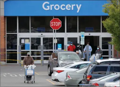  ?? (AP/Julio Cortez) ?? A shopper leaves a Walmart store last week in Cockeysvil­le, Md. Walmart said recently that it “proactivel­y rolled out many safety measures” was not yet not putting “a timetable on making modificati­ons.”