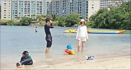  ?? MAR-VIC CAGURANGAN/AFP ?? This photo taken on Friday shows tourists on a beach in Guam’s capital, Hagatna.