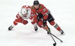  ?? NAM Y. HUH/AP ?? Blackhawks left wing Brandon Hagel, right, controls the puck against Red Wings left wing Troy Stecher during the first period on Sunday.