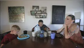  ?? RICK BOWMER ?? Misty Dotson shares dinner with her son’s at their home Tuesday, Aug. 20, 2019, in Murray, Utah. Dotson is a 33-year-old single mother of two boys, ages 12and 6, who goes to Planned Parenthood for care through the Title X program. Dotson is among the 39,000 people received treatment from Planned Parenthood of Utah in 2018under a federal family planning program called Title X. The organizati­on this week announced it is pulling out program rather than abide by a new Trump administra­tion rule prohibitin­g clinics from referring women for abortions.