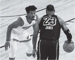  ?? MIKE EHRMANN Getty Images ?? The Heat’s Jimmy Butler defends LeBron James of the Lakers during the fourth quarter in Game 5 of the 2020 NBA Finals in Lake Buena Vista.