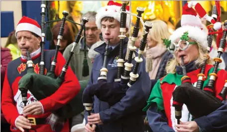  ??  ?? Members of New Ross and district pipe band and FCA pipe band performing on South Street before Christmas.