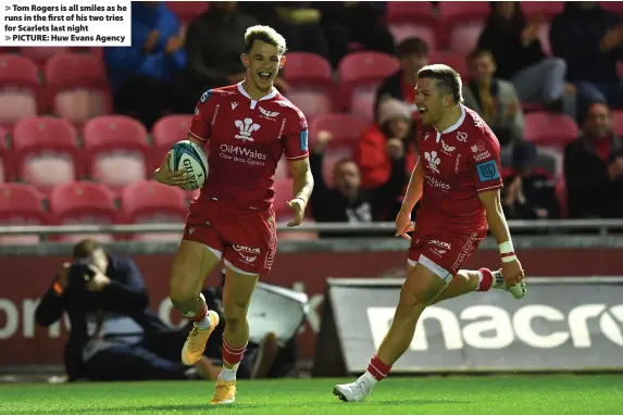  ?? ?? Tom Rogers is all smiles as he runs in the first of his two tries for Scarlets last night
PICTURE: Huw Evans Agency