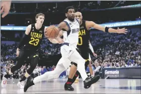  ?? TONY GUTIERREZ/AP ?? DALLAS MAVERICKS GUARD KYRIE IRVING (front) drives to the basket past Utah Jazz forward Lauri Markkanen (23) and Talen Horton-tucker (0) in Dallas on Tuesday.