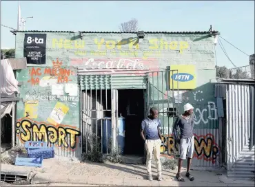  ?? PHOTO: REUTERS ?? Residents stand outside a spaza convienien­ce shop in Cape Town’s Imizamo Yethu township. The government should aid the myriad budding entreprene­urs who face obstacles to business developmen­t due the lack of affordable workspaces, says the writer.