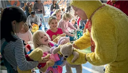  ?? MURRAY WILSON/STUFF ?? Amy Frith, 5, is amused by Te Manawa’s chief executive Andy Lowe in his bear costume.