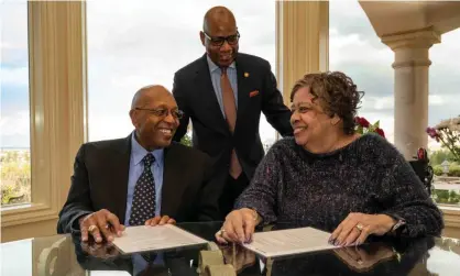  ?? Photograph: Paul "P A." Greene/AP ?? Calvin Tyler and his wife Tina sign the $20m pledge to students at Morgan State in Baltimore. The gift is the largest ever private donation from a former student.
