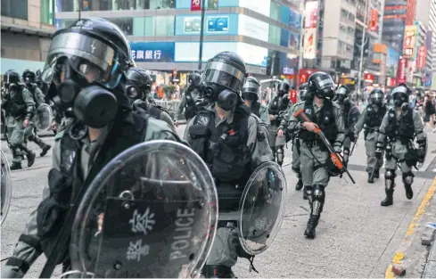  ??  ?? MUST BE PROTECTED: Police clear a road in the Mongkok district in Hong Kong last week. The Hong Kong police said many of its officers have had personal details leaked online.