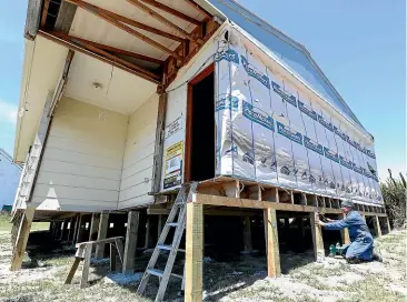  ?? JOHN BISSET/STUFF ?? Jim Kroening attaches anchor plates to the South Canterbury Deerstalke­rs Associatio­n’s clubrooms that are now sitting on a new site.