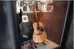  ?? —AFP photos ?? In these file photos, the guitar used by musician Kurt Cobain during Nirvana’s famous MTV Unplugged in New York concert in 1993, is displayed in the window of the Hard Rock Cafe Piccadilly Circus in central London prior to the auction of the guitar in Beverly Hills in June.