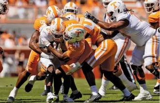  ?? TENNESSEE ATHLETICS PHOTO BY ANDREW FERGUSON ?? Sophomore linebacker Elijah Herring tackles sophomore running back Dylan Sampson during Saturday afternoon’s Orange & White game inside Neyland Stadium.