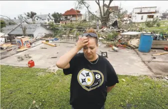 ?? Charlie Neibergall / Associated Press ?? Crystal Jensen stands in front of what’s left of her shattered home in Marshallto­wn, Iowa. Forecastin­g models early Thursday had showed only a slight chance of strong thundersto­rms.