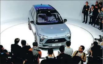  ?? REUTERS ?? People gather at the booth of Chinese electric vehicle startup Nio, as it unveiled its ES8 SUV model at the internatio­nal auto show in Shanghai on Wednesday.