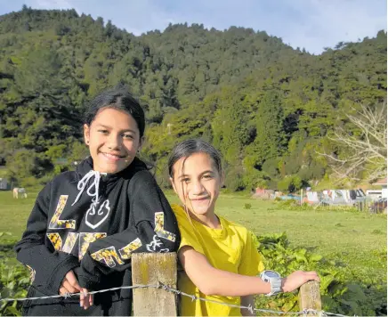  ??  ?? Ohine Riini-Reweti, 11 (left) and Desrae Collier, 10, on whanau land where their family live communally next to Te Urewera, the homeland of the Tu¯hoe people.