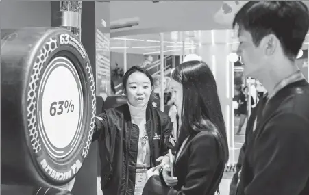  ?? PROVIDED TO CHINA DAILY ?? A Michelin employee (left) addresses visitor queries during the sixth China Internatio­nal Import Expo in Shanghai in November.