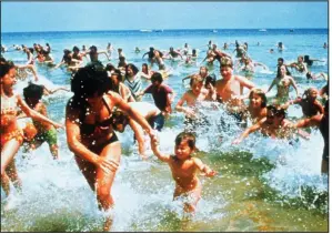  ??  ?? Steven Spielberg’s Jaws has been credited with causing America’s fascinatio­n with sharks. Here’s the iconic scene of the panicked crowd scrambling to reach shore. For the past 30 years, Discovery’s Shark Week has kept that interest alive and swimming.