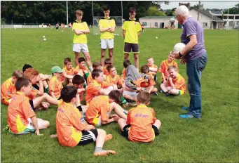  ??  ?? Eamon Ryan coaching the U-9s with junior coaches watching on at the Macroom GAA Cúl Camp.