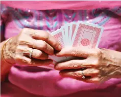  ??  ?? File photo shows a bridge player holding cards during a game of bridge. — AFP photo