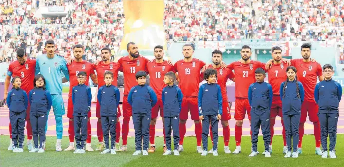  ?? Photo / Getty Images ?? Iran’s players stood silently as their national anthem was played before the game against England.