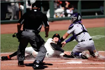  ?? AP PHOTO BY JED JACOBSOHN ?? San Francisco Giants’ Wilmer Flores is tagged out at home by Colorado Rockies’ Tony Wolters during the second inning of a baseball game in San Francisco, Thursday, Sept. 24.