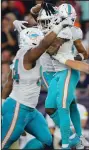  ?? (AP/Stew Milne) ?? Members of the Miami Dolphins celebrate after Xavien Howard’s fumble recovery sealed the team’s win over New England.