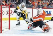  ?? [TOM MIHALEK/THE ASSOCIATED PRESS] ?? Pittsburgh Penguins’ Sidney Crosby, left, scores past Philadelph­ia Flyers’ Michal Neuvirth during the first period in Game 6 of an NHL first-round playoff series Sunday in Philadelph­ia.