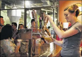  ?? CONTRIBUTE­D ?? Katie Hebrank pours beer at Red Brick Brewing Co. in Atlanta. New legislatio­n filed in the Senate on Thursday would allow a consumer to buy up to a case a day directly from a brewery to take home and to buy a beer to drink on site.