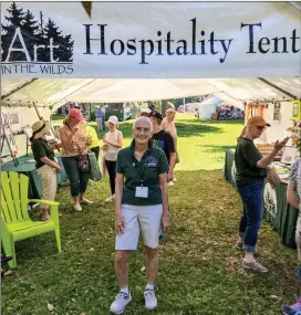  ?? Photo by Theresa Auriemmo ?? Pictured is President of the Art in the Wilds Committee, Julie Cleland, standing at the Art in the Wilds Hospitalit­y Tent in Evergreen Park on June 25.