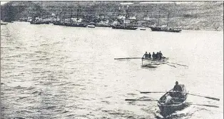  ?? SUBMITTED PHOTO ?? Fishermen come out from West St. Modeste in the Straits of Belle Isle to welcome the coasting vessel Virginia Lake. Note the dressy hats (possibly bowlers) on some of the men. Several hefty schooners, likely participan­ts in the summer fishery, are...