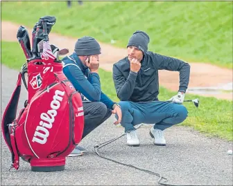  ??  ?? Gus Hay (left) tries to help Joakim Lagergren solve a problem on the Road Hole at St Andrews during the 2019 Dunhill