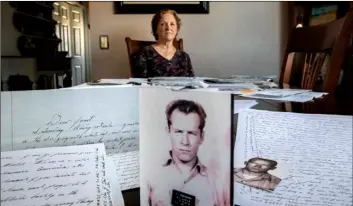  ?? AP Photo/David Goldman ?? Janet Uhlar sits for a photo at her dining room table with an arrangemen­t of letters and pictures she received through her correspond­ence with imprisoned Boston organized crime boss James “Whitey” Bulger, on Jan. 31 in Eastham, Mass.