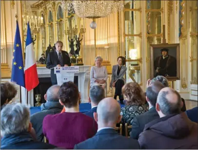  ?? The Associated Press ?? RETURNED: Henrietta Schubert is seated with French Culture Minister Audrey Azoulay, right, next to a 16th century painting attributed to the school of Joos van Cleve, “Portrait of a Man,” as her cousin Christophe­r Bromberg, left, addresses the media...
