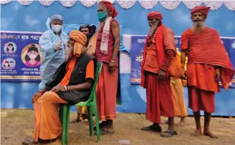  ?? — PRITAM BANDYOPADH­YA ?? A health worker takes a sample from a sadhu on his way to Gangasagar for Covid- 19 test at a transit camp in Kolkata on Friday.