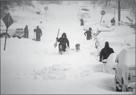  ?? AP/Star Tribune/ALEX KORMANN ?? Neighbors work together Sunday to clear as much snow as possible from their street in Duluth, Minn. The city had received 21.7 inches of snow by noon Sunday.